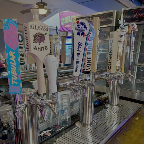 Close-up of multiple beer taps with various brand handles at Pizzeria 131's bar.