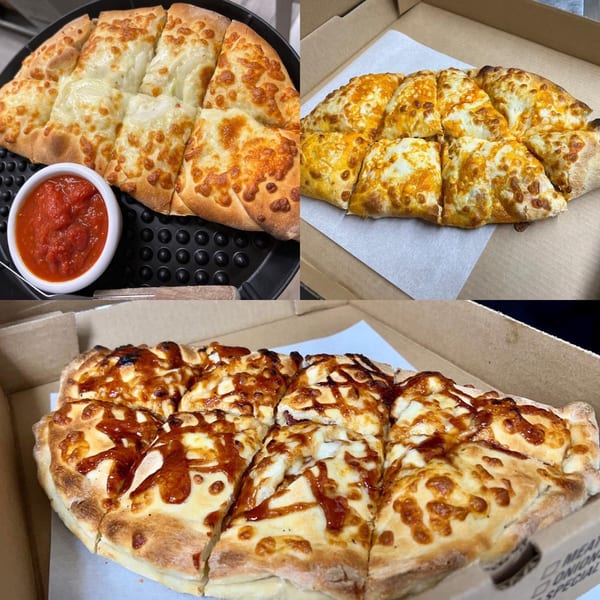 Three different Pizzeria 131 cheese breads, two plain and one with BBQ sauce, in boxes.